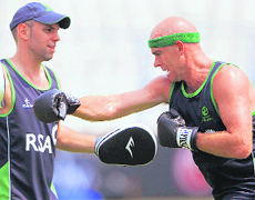 Ireland bowler Trent Johnston (R) throws punches with a teammate during a training session at the Eden Gardens in Kolkata on Monday.