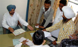 Commissioner Raminder Singh checks attendance at a government office in Mamdot block of Ferozepur district on Monday.