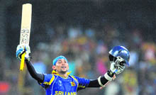 Tillakaratne Dilshan raises his bat in celebration after scoring a century during the quarter-final match against England at The R. Premadasa Cricket Stadium in Colombo on Saturday. Sri Lanka won by 10 wickets.