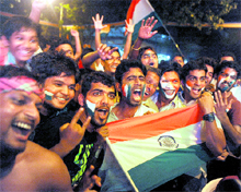 Fans pose with the Tricolour as they celebrate India's victory in the semi-final match against Pakistan, in Mumbai streets on Wednesday