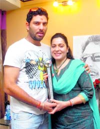 Yuvraj Singh, Man of the Tournament in the recent World Cup, along with his mother Shabnam Singh and trophy after returning to his hometown Chandigarh on Wednesday.