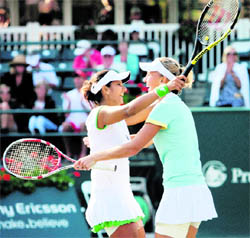 Sania Mirza (L) celebrates with Elena Vesnina after winning the doubles title at the Family Circle Cup tournament in Charleston on Sunday