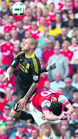 Liverpool's Martin Skrtel (L) jumps to win a header under a challenge from Arsenal's Robin van Persie in London on Sunday.