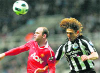 Manchester United's Wayne Rooney (L) and Newcastle United�s Fabricio Coloccini jump for the ball at St James' Park 