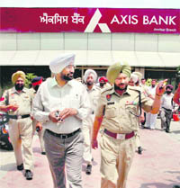 Police officials inspect the Axis Bank on Majitha Road in Amritsar on Thursday.