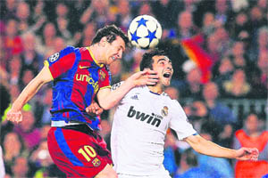 Barcelona's Lionel Messi (L) vies with Real Madrid's Raul Albiol at Camp Nou stadium in Barcelona on Tuesday. 
