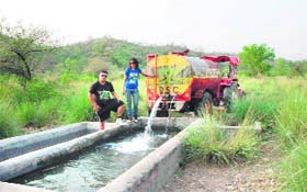 Nikhil Sanger and Sonika Mann fill a water hole in the Kandi forest area