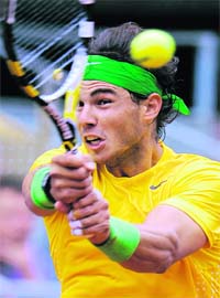 Rafael Nadal hits a return against Michael Llodra during their match at the Madrid Masters