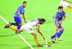 Pakistan's Shakeel Abbassi (C) controls the ball against Malaysia on Saturday. Pakistan won 3 - 2