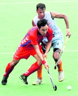 South Korea's Yoon Sung-hoon (L) battles for the ball with India's Sunli Sowmarpet during their match in Ipoh on Sunday. South Korea won 2-1.