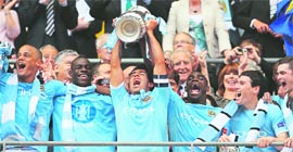 Manchester City's Carlos Tevez (C) celebrates with team-mates after his team beat Stoke 1-0 during the FA Cup final in London on Saturday.