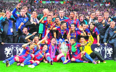 Barcelona's players celebrate with the trophy after winning the UEFA Champions League final match at Wembley Stadium in London on Saturday.