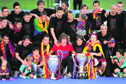Barcelona's players pose with their Champions League (L) and Liga trophies during a celebration with supporters in Barcelona on Sunday. 
