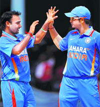 Amit Mishra (L) is congratulated by captain Suresh Raina after taking the wicket of West Indies opener Kirk Edwards during the second one-day match in Port-of-Spain, Trinidad 