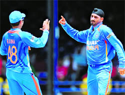 Harbhajan Singh (R) and captain Suresh Raina celebrate the fall of a wicket in Antigua on Saturday