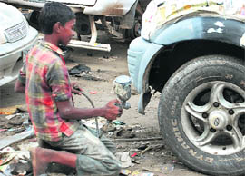 Childhood lost: A boy works at a car repair workshop on the World Day Against Child Labour at Manimajra in Chandigarh on Sunday.