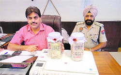 Nawanshahr SSP Narinder Bhargav and SP Dharam Singh Uppal with fake currency notes and the hi-tech printer-cum-scanner used by ex-army official Surinder Pal in Nawanshahr on Sunday.