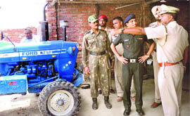 Police and Army officials inspect the blast site at Bille Daria village; (below) another unexploded shell that was recovered from a scrap dealer. 