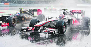 Vitaly Petrov attempts to overtake Mclaren Mercedes�s Jenson Button in heavy rain during the Canadian Formula One Grand Prix in Montreal 