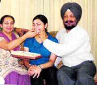 Amolpreet Kaur, who topped in the PSEB Class X examination by securing 96.46% marks, celebrates with her family in Anandpur Sahib on Tuesday.