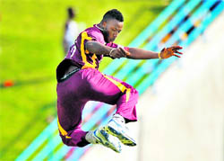 West Indies� Andre Russell leaps in the air to celebrate the dismissal of Praveen Kumar in St John�s on Monday