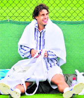 Rafael Nadal rests after a training session on the eve of the Wimbledon Championships at the All England Tennis Club, in London