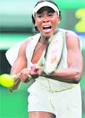 Venus Williams hits a return against Kimiko Date-Krumm at Wimbledon Championships in London