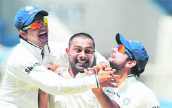 Praveen Kumar (C) celebrates with Suresh Raina (L) and Virat Kohli after taking the wicket of Shivnarine Chanderpaul in Jamaica on Thursday.