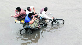 A rickshaw negotiates a waterlogged road after heavy rain in Patiala on Saturday.