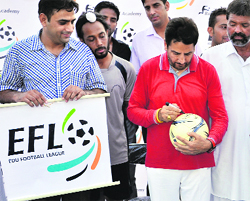 Gurdas Mann (R) signs the match ball at the YFC ground in Rurka Kalan