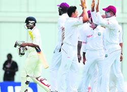 West Indies players celebrate the wicket of Abhinav Mukund (L) in Barbados