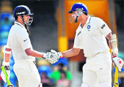 Rahul Dravid (L) is congratulated by VVS Laxman after completing his half-century against West Indies at Kensington Oval on Friday
