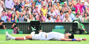 Novak Djokovic lies on the ground after beating Rafael Nadal in the men's single final at Wimbledon on Sunday. Djokovic won 6-4, 6-1, 1-6, 6-3. � AFP