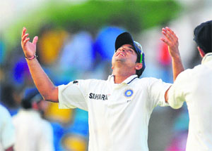 Suresh Raina looks at the sky after rain stopped play on the fifth day of the second Test against West Indies at Kensington Oval in Barbados on Saturday. India lead the series 1-0. 