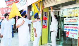 Ruling alliance workers force a shopkeeper to down the shutter of his shop 