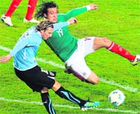 Uruguayan forward Diego Forlan (L) and Mexican Hector Reynoso in action during their Copa America match in La Plata