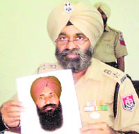 The SSP of Fatehgarh Sahib shows the sketch of the man suspected to have attacked the Vice-Chancellor of Sri Guru Granth Sahib World University on Monday. 