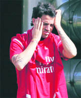 Arsenal�s Cesc Fabregas rubs his head as he arrives for a team training session at London Colney on Tuesday. 