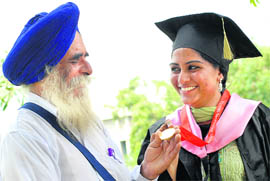A man sees his daughter's gold medal after the annual convocation of the Punjab Technical University in Jalandhar on Thursday. Dr Vijay P Bhatkar, chairman of ETH Research Lab, Pune, was the chief guest. About 145 students received degrees and awards on the occasion.