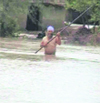 A villager wades through his flooded field in Kapurthala