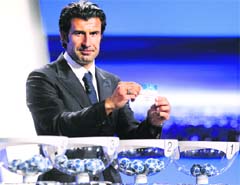 Portuguese football player Luis FIgo shows the name of AC Milan during the draw for the UEFA 2011-2012 Champions League in Monaco