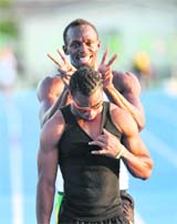 Jamaica's Usain Bolt (top) shares a light moment with a teammate during a training session at The Athletes Village in Daegu on Wednesday