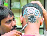 A Messi fan undergoes a special hair-cut to sport the footballer�s name in Howrah. 