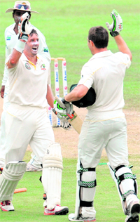 Shaun Marsh (R) and Michael Hussey (C) celebrate as Mahela Jayawardene looks on during the third day of the second Test in Pallekele on Saturday