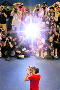 Novak Djokovic kisses the trophy after defeating Rafael Nadal during the men's final at the USTA Billie Jean King National Tennis Center in New York on Monday