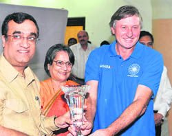 Sports minister Ajay Maken (L) and Indian hockey coach Michael Jack Nobbs of Australia hold the Asian Champions Trophy during a function in New Delhi 