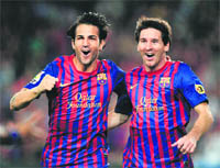 Barcelona�s Lionel Messi (R) celebrates with Cesc Fabregas after scoring during the Spanish league match against Osasuna in Barcelona on Saturday.