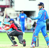 England�s Ravi Bopara hits a boundary against India as MS Dhoni looks on. India lost the ODI series 3-0.