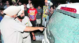 A policeman points towards a damaged car in Patiala on Tuesday.