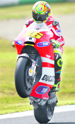 Ducati MotoGP rider Valentino Rossi performs a wheelie during a practice session for the Japanese Grand Prix in Motegi on Friday